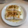 Deliciously baked cod fillet garnished with herbs and spices