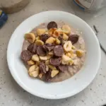 Delicious bowl of Easy Snickers Overnight Oats topped with chocolate and nuts