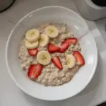 Bowl of high-protein overnight oats topped with fruits and nuts.