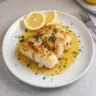 Lemon Butter Pan Seared Cod on a plate garnished with herbs and lemon slices