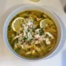 Lemon Ginger Turmeric Chicken and Rice Soup in a bowl, garnished with herbs.