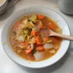 Low-calorie cabbage fat burning soup in a bowl with fresh vegetables