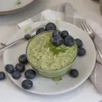 Bowl of Matcha Overnight Oats topped with fresh fruits and nuts