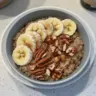 Bowl of nutritious quinoa oatmeal breakfast topped with fruits and nuts