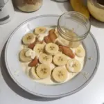 Delicious Protein Banana Pudding topped with banana slices and crushed nuts