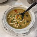 Bowl of Santa Fe Green Chile Chicken Soup with fresh ingredients and spices