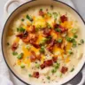 Bowl of tasty loaded potato soup topped with cheese and green onions