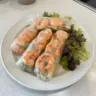 Thai shrimp rolls garnished with fresh herbs served with peanut sauce