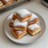 Freshly made Vanilla French Beignets dusted with powdered sugar.
