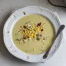 Bowl of creamy Zucchini Corn Chowder garnished with herbs