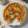 Delicious Bacon and Cheddar Quiche sliced and served on a plate