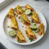 Plate of baked chicken tacos with fresh toppings and cheese