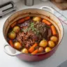Delicious Dutch Oven Pot Roast served with vegetables and herbs for a hearty meal.