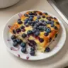 Blueberry Buttermilk Pancake Casserole served in a baking dish with fresh blueberries