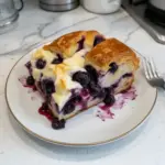 Delicious Blueberry Cream Cheese Croissant Casserole served warm and topped with blueberries.