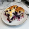 Delicious Blueberry Cream Cheese Croissant Casserole served warm and topped with blueberries.