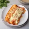 Cheesy baked chicken enchiladas garnished with fresh cilantro