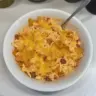 A delicious serving of Dorito Chicken Casserole topped with cheese and Doritos.
