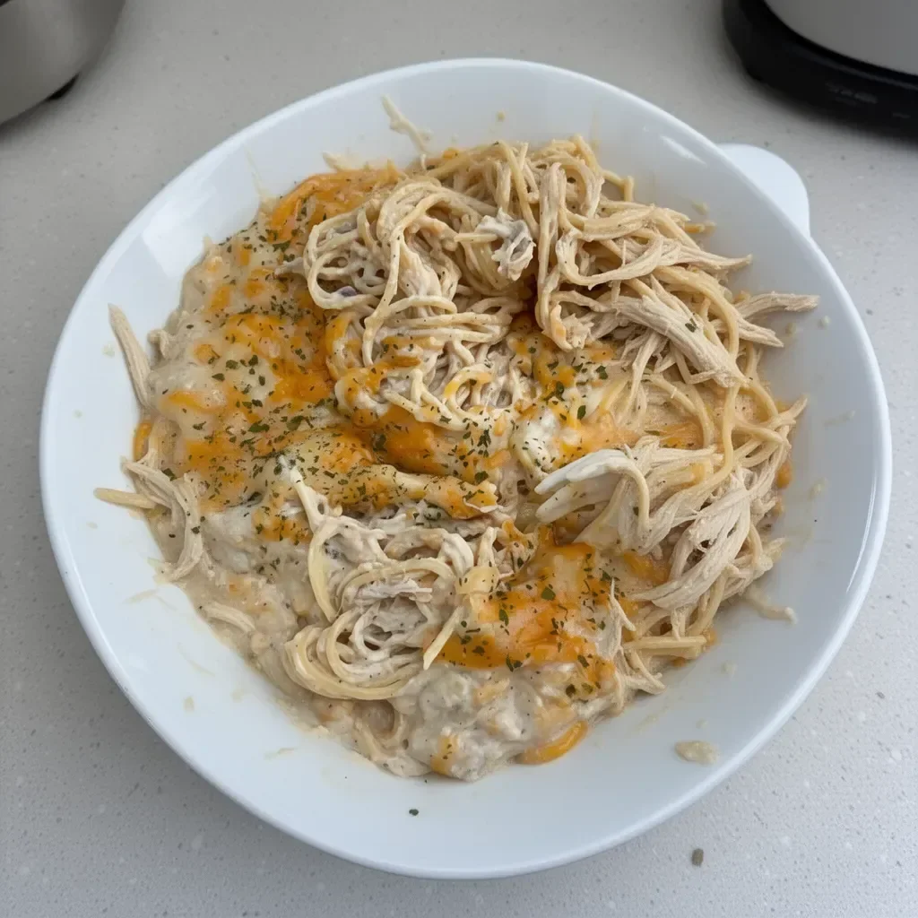 Bowl of easy Chicken Tetrazzini topped with parsley and cheese