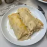 Delicious creamy white chicken enchiladas topped with cheese and cilantro