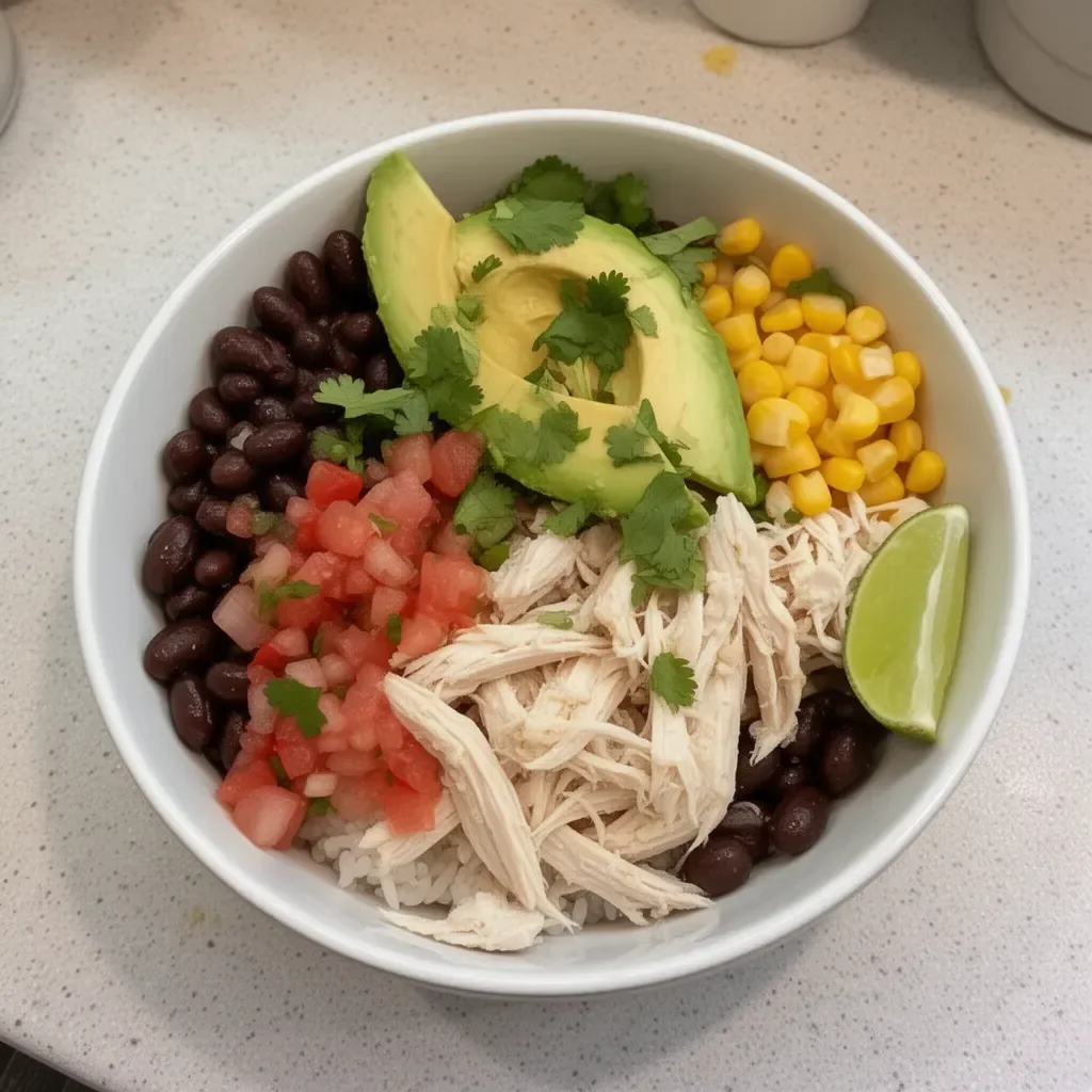 Easy rotisserie chicken burrito bowl garnished with fresh toppings