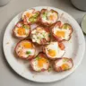 Delicious ham and cheese egg cups served on a plate for breakfast.