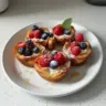 Delicious French Toast Cups served with syrup and fresh berries.