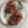 Marinated venison backstrap served on a plate with herbs and spices