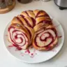 Freshly baked Raspberry Swirl Brioche Loaf with vibrant raspberry filling