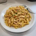 Delicious rotisserie chicken pasta dish served in a bowl with fresh herbs