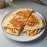 Rotisserie chicken quesadilla with melted cheese and fresh ingredients