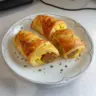Delicious sausage egg breakfast roll-ups served on a plate for a quick morning meal.