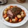 Tender crock pot sirloin tip roast with colorful vegetables in a slow cooker