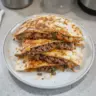 Delicious venison quesadilla served with toppings and salsa