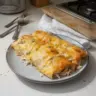 Delicious white chicken enchiladas topped with creamy sauce and cheese