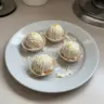 Delicious lemon meringue tart truffles arranged on a decorative plate.