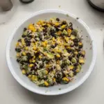 Colorful black bean salad with fresh vegetables and herbs in a bowl