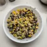 Colorful black bean salad with fresh vegetables and herbs in a bowl