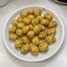 Plate of cheesy zucchini tots, golden brown and crispy