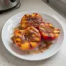 Grilled peaches topped with cinnamon and brown sugar on a plate