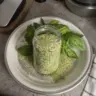 Homemade basil salt in a glass jar with fresh basil leaves