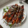 Honey Chipotle Grilled Chicken Skewers on a plate garnished with herbs