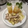 Glass of Honey Ginger Lemonade garnished with lemon slices and ginger