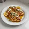 Delicious Hot Honey Feta Chicken plated with fresh herbs and a drizzle of honey