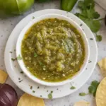 Delicious roasted tomatillo salsa served in a bowl with tortilla chips