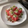 Watermelon feta bites with fresh basil arranged on a platter