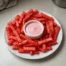 Delicious watermelon fries served with a strawberry yogurt dip for a refreshing treat