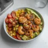 Avocado Corn Salad with Grilled Shrimp served in a colorful bowl