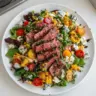 Delicious balsamic steak salad topped with gorgonzola and grilled corn