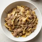 Delicious plate of beef and noodles garnished with herbs